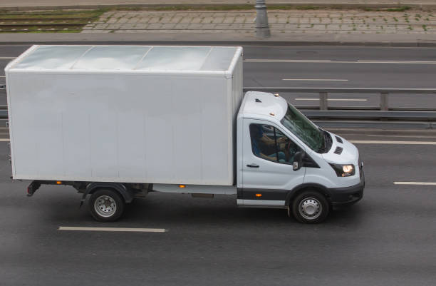 truck with a container moves along the road in the city