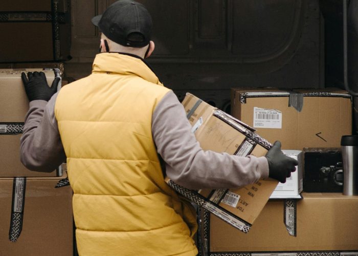 Deliveryman organizing packages into a van for distribution.
